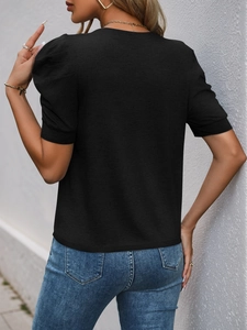 Detail of female model wearing black puff sleeve casual t-shirt with textured fabric