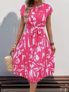 Détail de robe plissée fuchsia avec imprimé géométrique et ceinture réglable