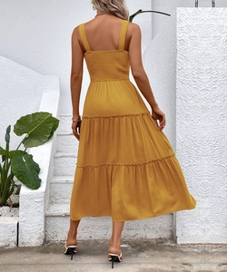 Detail of smocked elastic back and tiered skirt on a mustard yellow summer dress