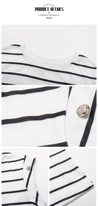 Detail of round neck striped top featuring decorative gold embossed shoulder buttons