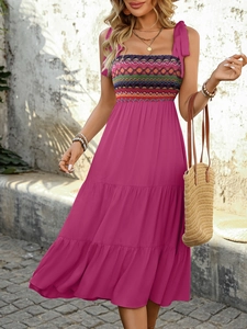 Detail of rose red bohemian dress featuring colorful geometric chest embroidery and tie straps