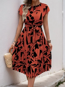 Détail d'une robe plissée élégante avec motifs abstraits et ceinture à la taille