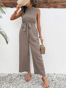 Detail of a beige sleeveless jumpsuit with black geometric prints and a waist tie belt