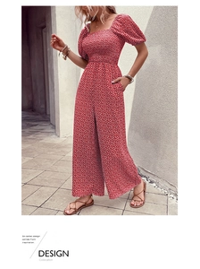 Detail of red floral romper with square neck, puff sleeves and wide leg design