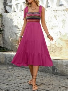 Detail of pink bohemian tiered dress featuring ethnic geometric smocked bodice and tie straps