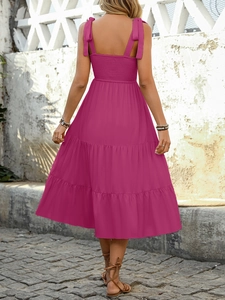 Detail of rose red tiered summer dress with smocked back and adjustable bow straps