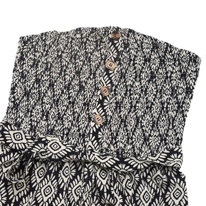 Detail of bohemian smocked bodice with wooden buttons and geometric print fabric