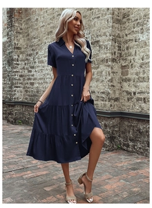 Detail view of the tiered skirt structure and navy blue fabric on a midi shirt dress