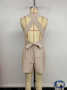 Détail d'un combishort dos nu beige montrant le nœud à la taille et la texture en lin