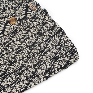 Detailed macro view of smocking fabric texture with geometric pattern and tortoise buttons