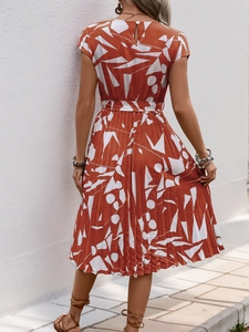 Vue arrière d'une robe plissée terre cuite avec motifs abstraits et ceinture nouée