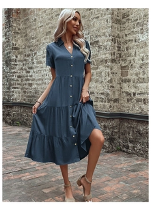 Detail of navy blue tiered midi shirt dress with button-up V-neckline in outdoor setting