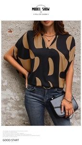 Detail of V-neck short sleeve blouse with abstract black and tan geometric print patterns