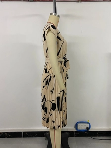 Détail d'une robe plissée beige à imprimé abstrait avec ceinture sur mannequin