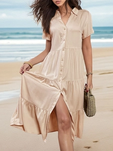 Champagne satin shirt dress with button-up front and tiered skirt on a sunny beach