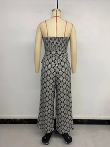 Detail view of black and white geometric print jumpsuit with elastic waist and smocked top