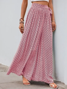 Detail of high-waist geometric print pants with side slit and waist-tie design