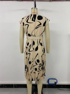 Détail d'une élégante robe midi plissée avec imprimé abstrait noir sur beige