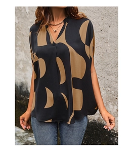 Detail of a casual V-neck blouse with abstract geometric print and loose batwing sleeves