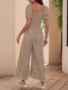 Detail view showing the back cut and drape of the brown floral jumpsuit with puff sleeves