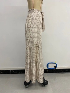Detail view of boho wide-leg pants featuring geometric floral prints and tiered design.