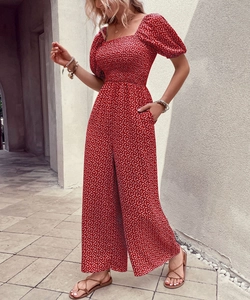 Detail of red floral romper featuring smocked bodice, square neck and puff sleeves