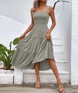 Detail of sage green smocked maxi dress with tiered skirt and textured fabric