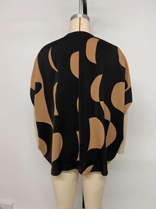 Detail of loose fit short sleeve shirt with khaki geometric patterns on black fabric
