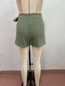 Détail d'un short taille haute texturé vert armée avec fermeture éclair invisible au dos