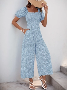 Detail of light blue floral wide-leg romper featuring square neck and puff sleeves