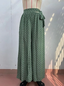 Close-up of green high-waisted wide-leg pants with geometric print and waist tie