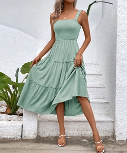 Detail of sage green tiered midi dress featuring a smocked bodice and square neckline