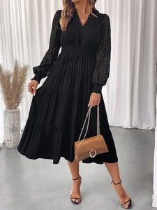 Detail of V-neck lace bodice and layered tiered skirt on black long sleeve dress