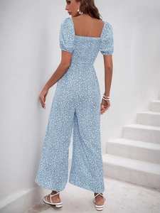 Rear view of a blue floral print jumpsuit featuring puff sleeves and elastic shirred back