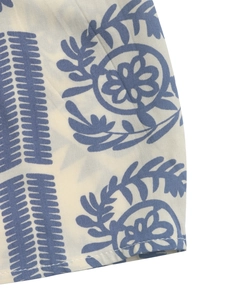 Detail of ethnic print fabric with blue floral patterns and stitched hemline
