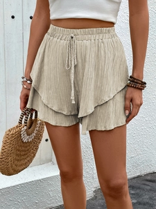 Close-up of beige textured fabric with tiered ruffles and adjustable drawstring waist