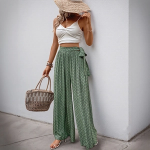 Summer resort outfit featuring green geometric print wide-leg pants and a white crop top