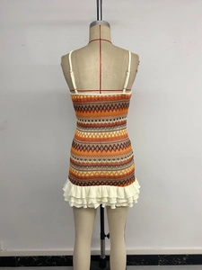 Detail of bohemian knit dress featuring geometric patterns and tiered lace hemline