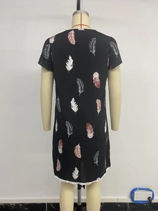 Detail of white pom pom lace trim on black summer dress with feather print