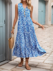Nahaufnahme des blauen Boho-Blumenmusters am gestuften ärmellosen Maxikleid mit Holzknöpfen