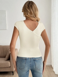 Elegante top in maglia a coste bianco crema con scollo a V e incrocio sulla schiena