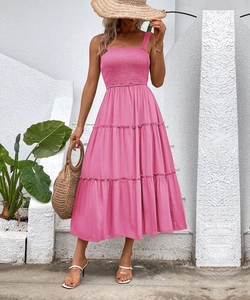 Detail of smocked bodice and tiered midi skirt on a bright pink summer dress
