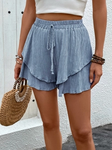 Macro detail of textured greyish-blue high-waisted shorts with double-layered ruffles