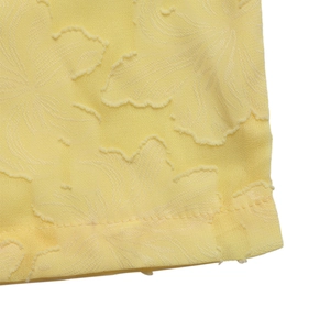 Makro-Detail der blassgelben Jacquard-Stoffstruktur mit zartem Blumenmuster