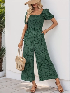 Detail of smocked square neck bodice and puff sleeves on animal print green jumpsuit