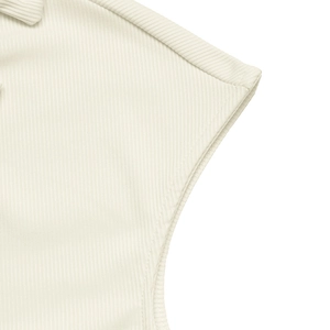 Dettaglio della trama a costine e delle cuciture su un top crema con scollo a V e maniche corte