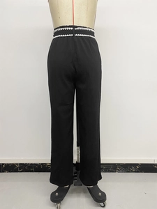 Detail view of high waist trousers featuring white scalloped lace trim on elastic waistband