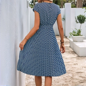 Navy blue geometric print midi dress with cap sleeves and tie-waist seen from behind