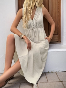 Detail of beige V-neck sleeveless dress with buttons and adjustable drawstring waist