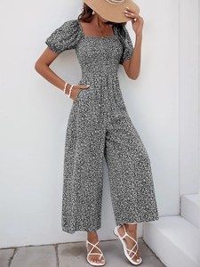 Detail of floral print jumpsuit featuring a square neck and short puff sleeves